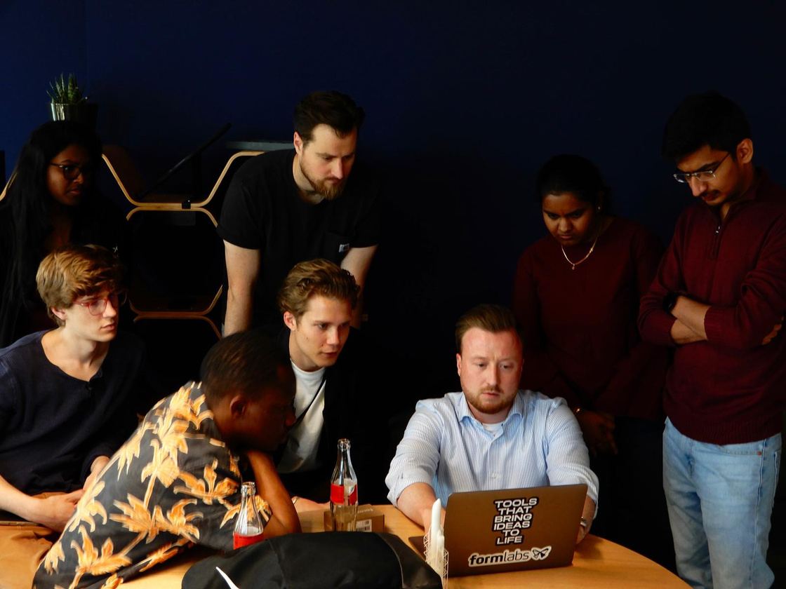 Students gathered around a laptop during a company visit
