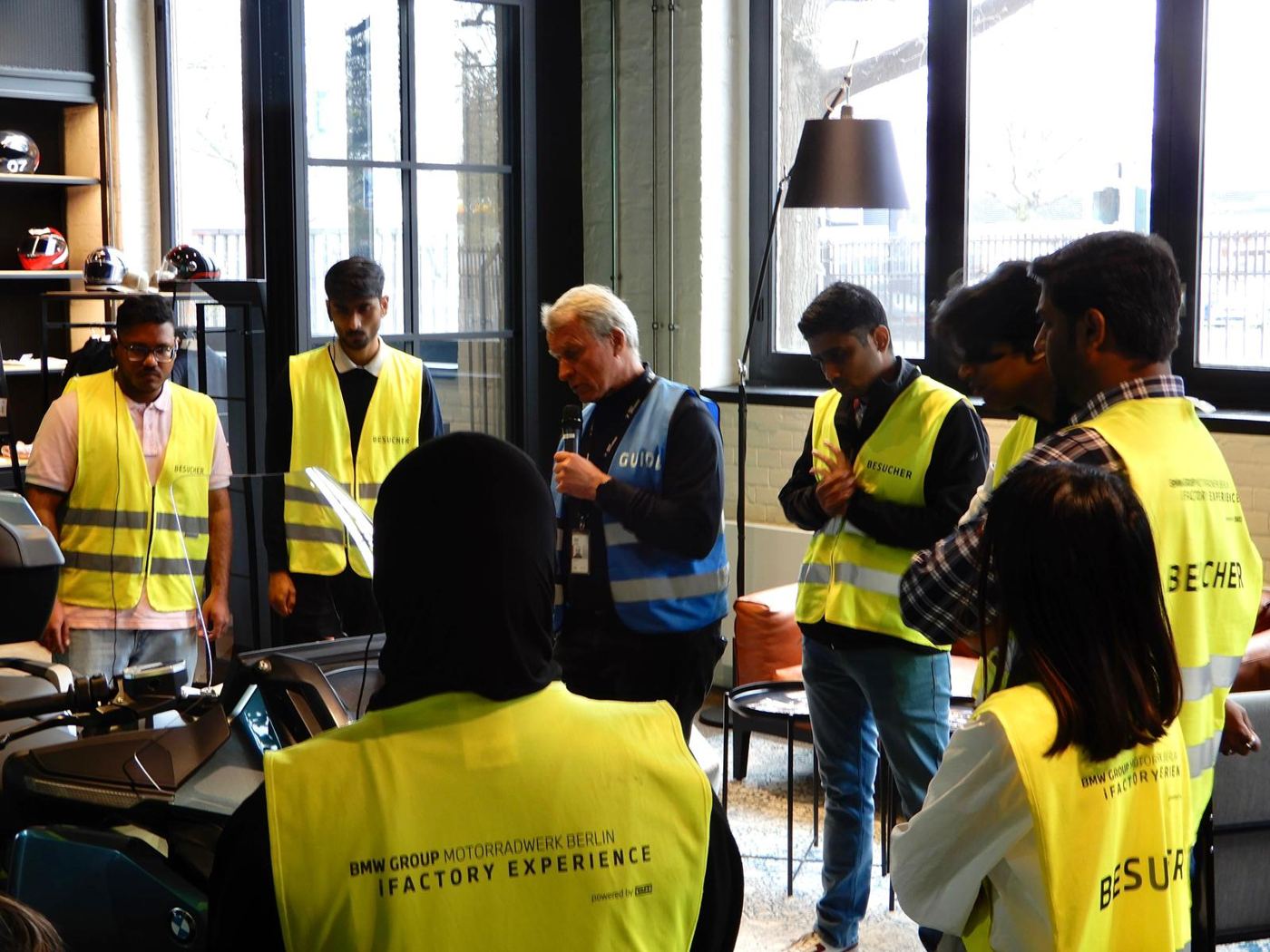 Guide briefing students in visitor vests at BMW Motorrad Berlin