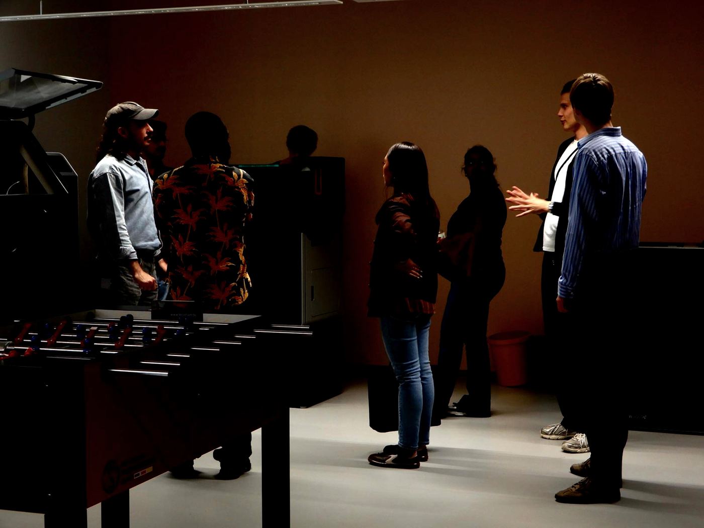 Students and hosts talking in a dimly lit company break room