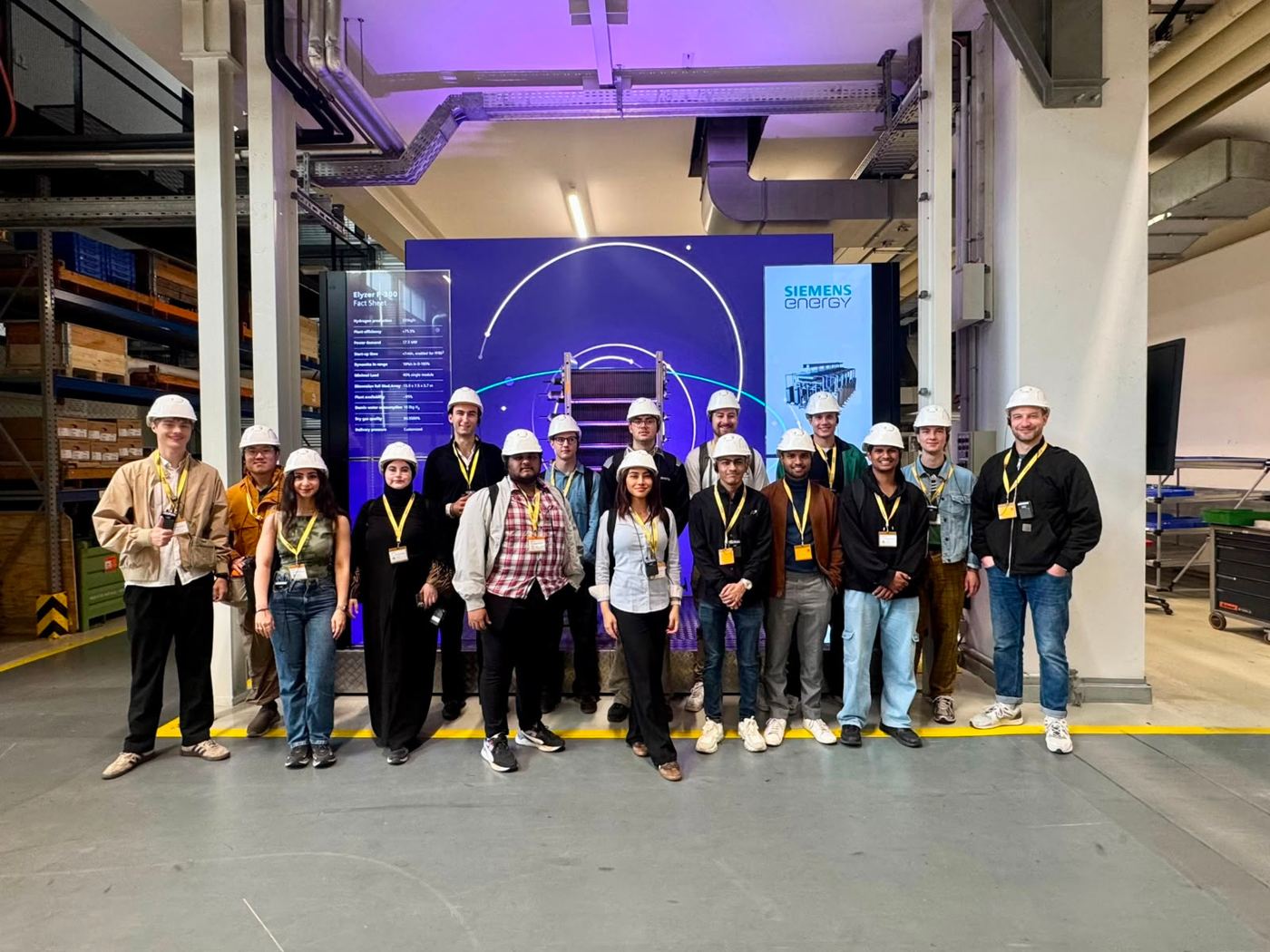 Students in hard hats in front of an electrolyzer at Siemens Energy